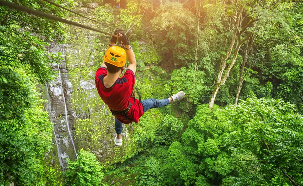 Ziplining over the jungle canopy near a waterfall